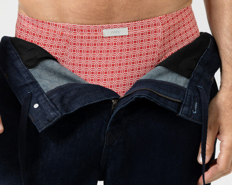 Man met open broek die zijn kleurrijke boxershort laat zien